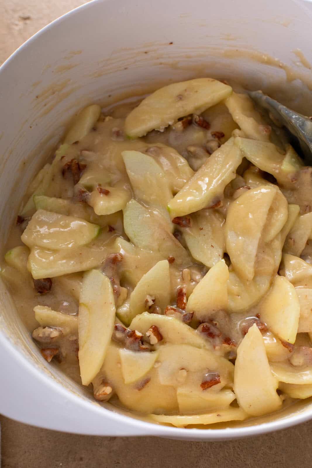 Fresh apple cake batter mixed in a white bowl.