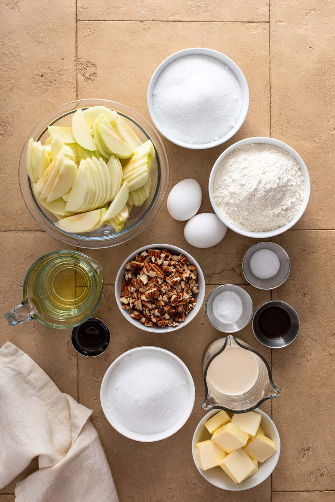 Ingredients for fresh apple cake arranged on a countertop.