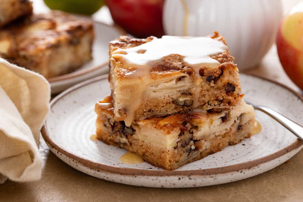 Two stacked slices of apple cake topped with dessert sauce.