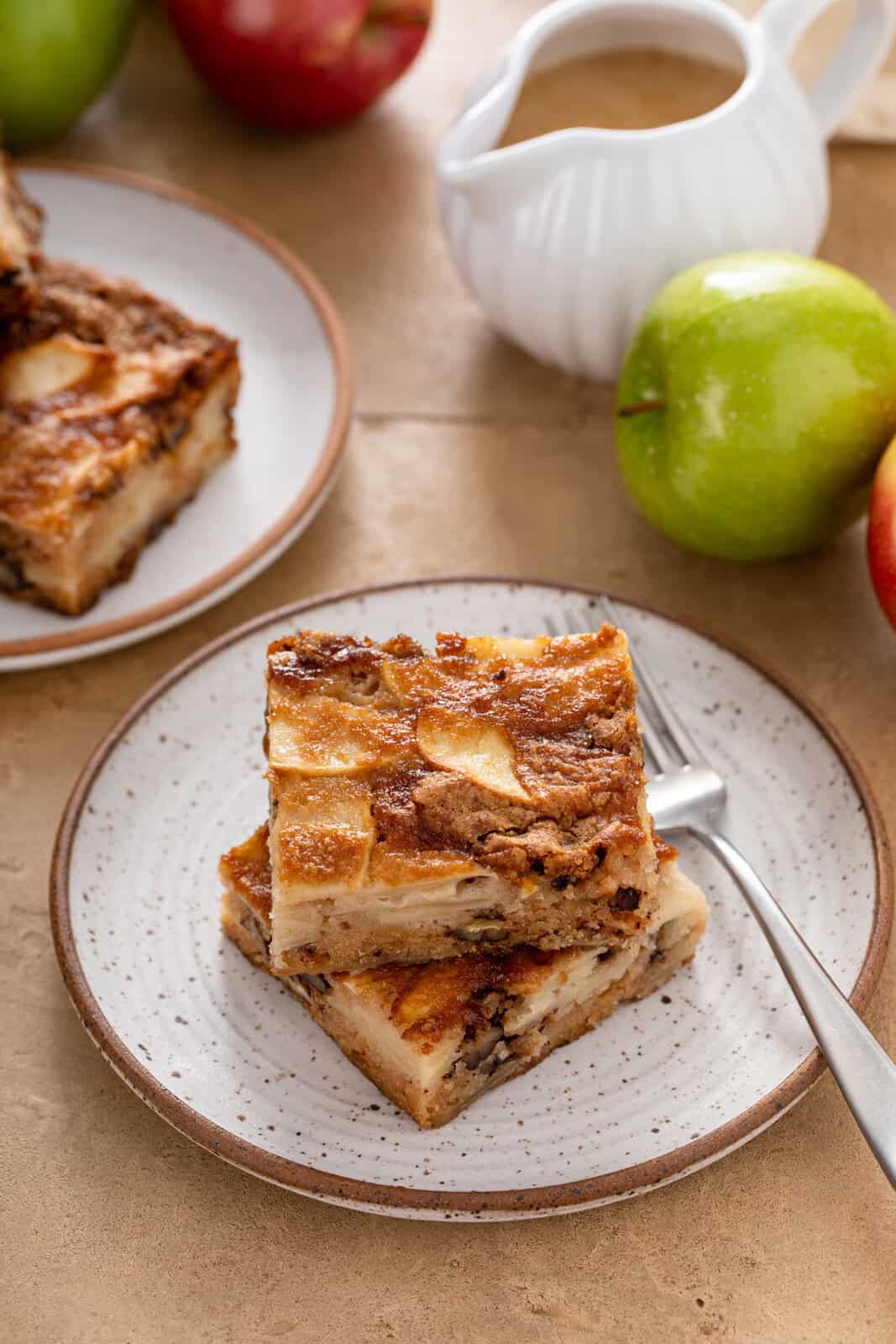 Two slices of apple cake stacked on a plate.