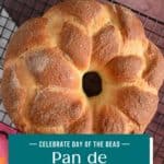 Baked loaf of pan de muerto cooling on a wire rack. Text overlay includes recipe name.