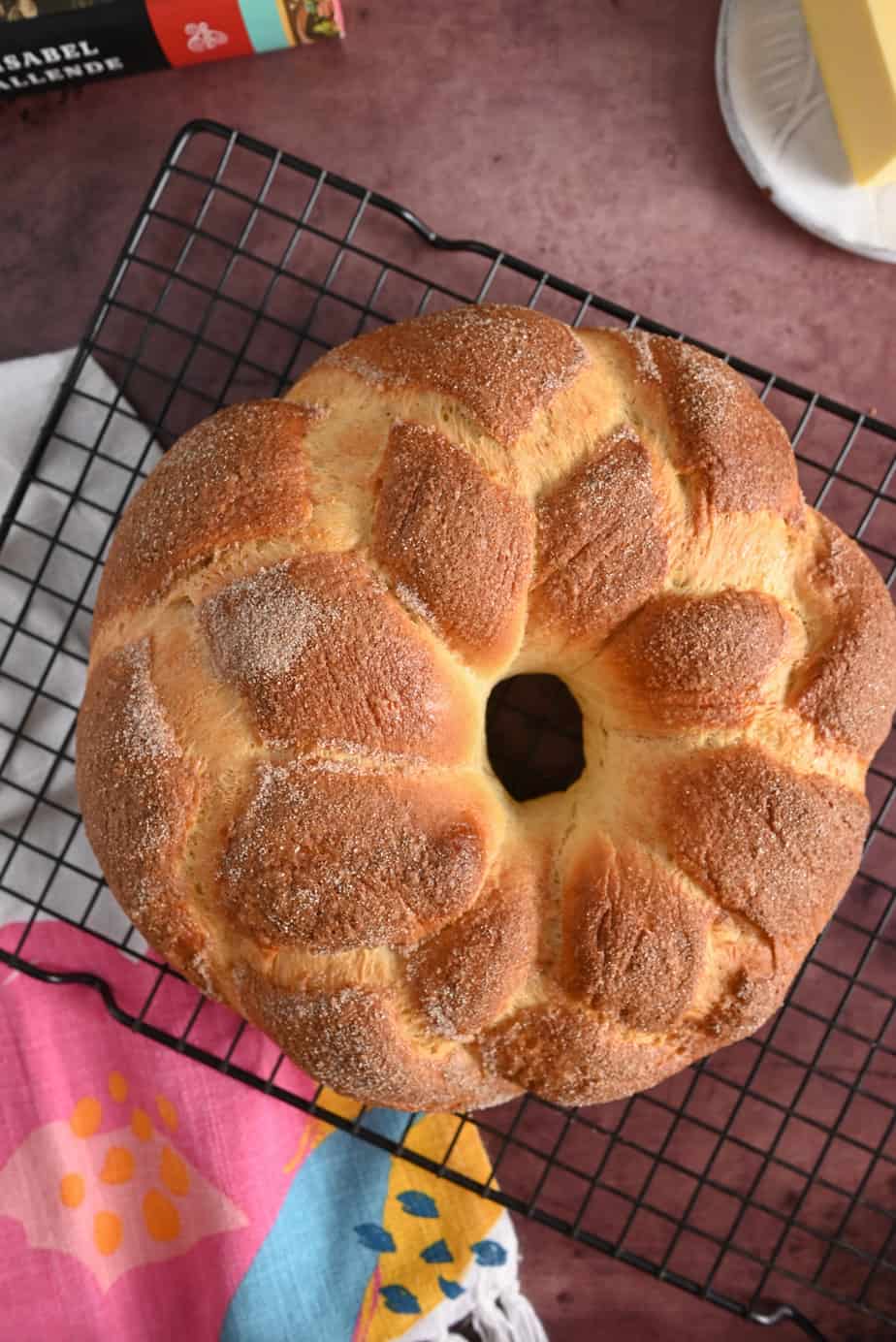 Baked loaf of pan de muerto cooling on a wire rack.