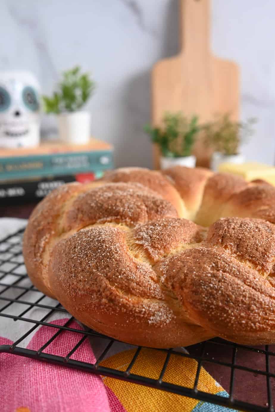 Close up image of the side of a loaf of pan de muerto, set on a cooling rack.