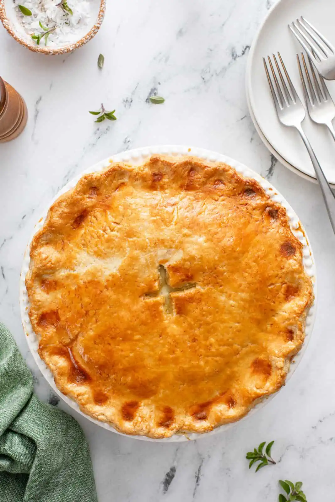 Overhead view of baked chicken pot pie on a marble countertop.