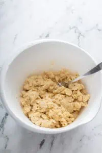 Shaggy pie dough in a white mixing bowl.