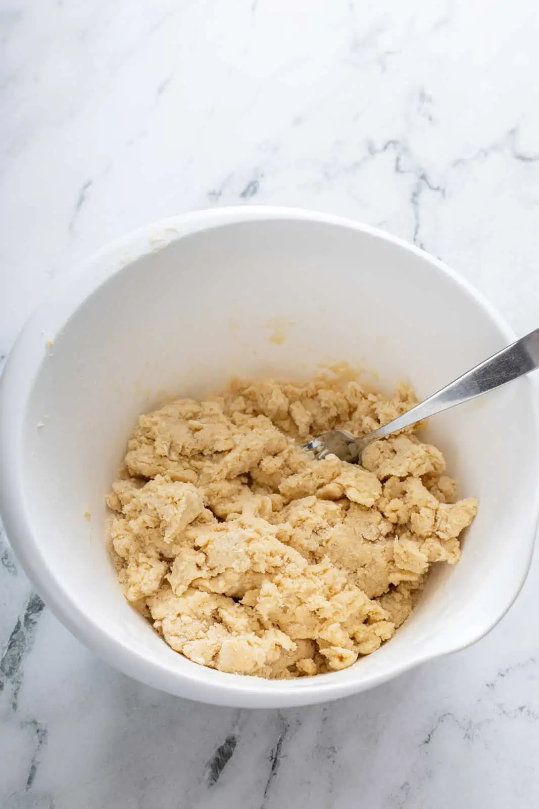 Shaggy pie dough in a white mixing bowl.