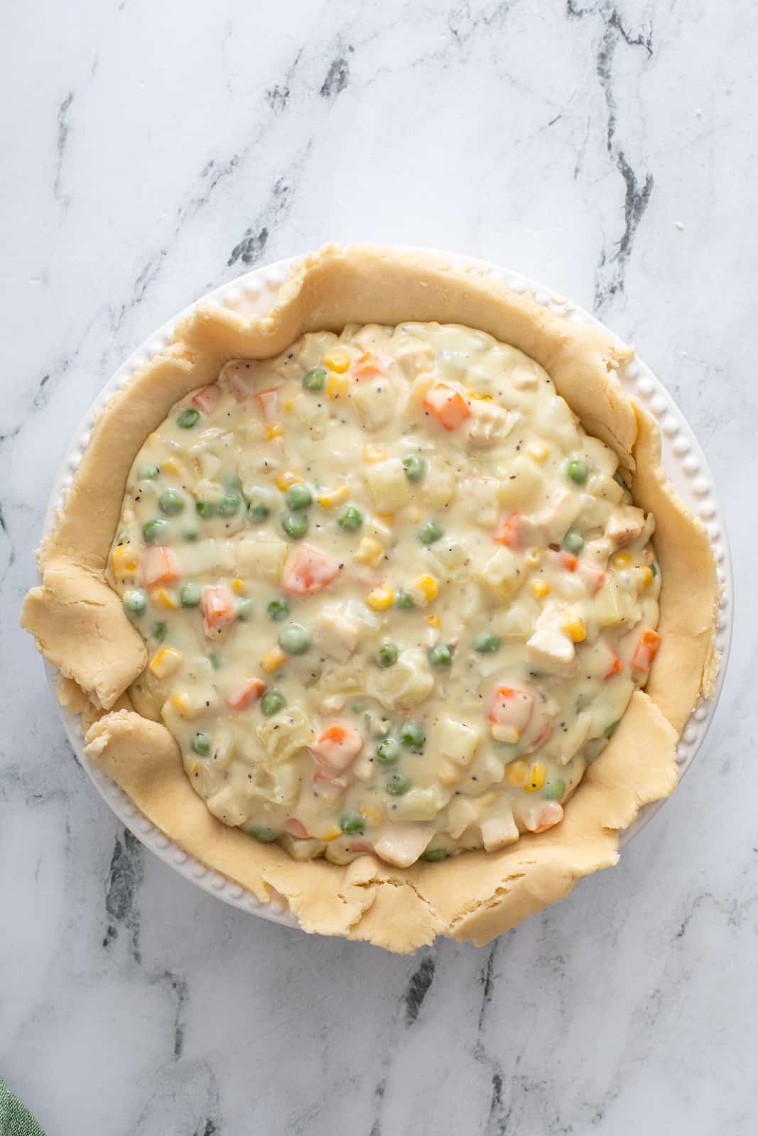 Chicken pot pie filling in a pie crust-lined pie plate.