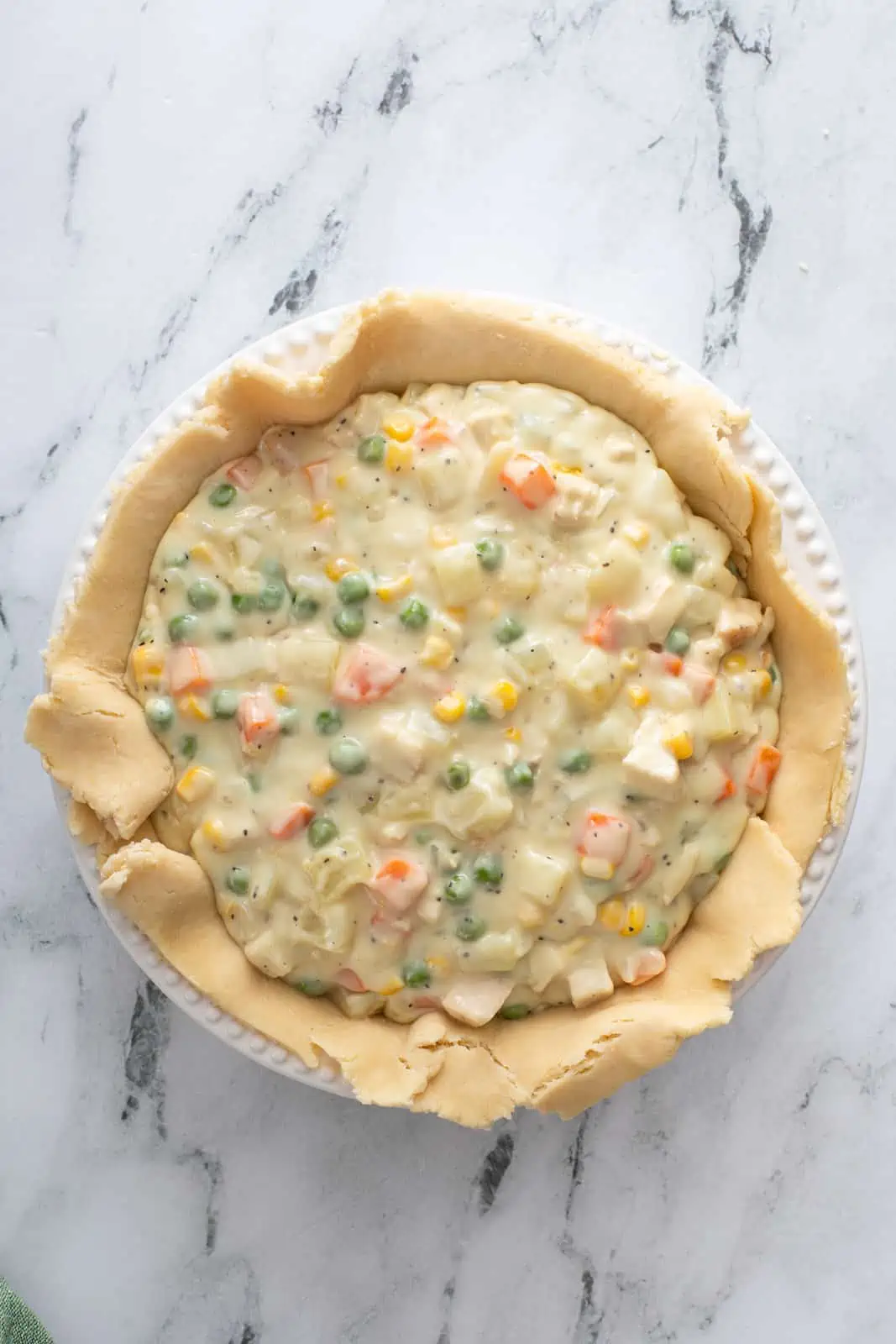 Chicken pot pie filling in a pie crust-lined pie plate.