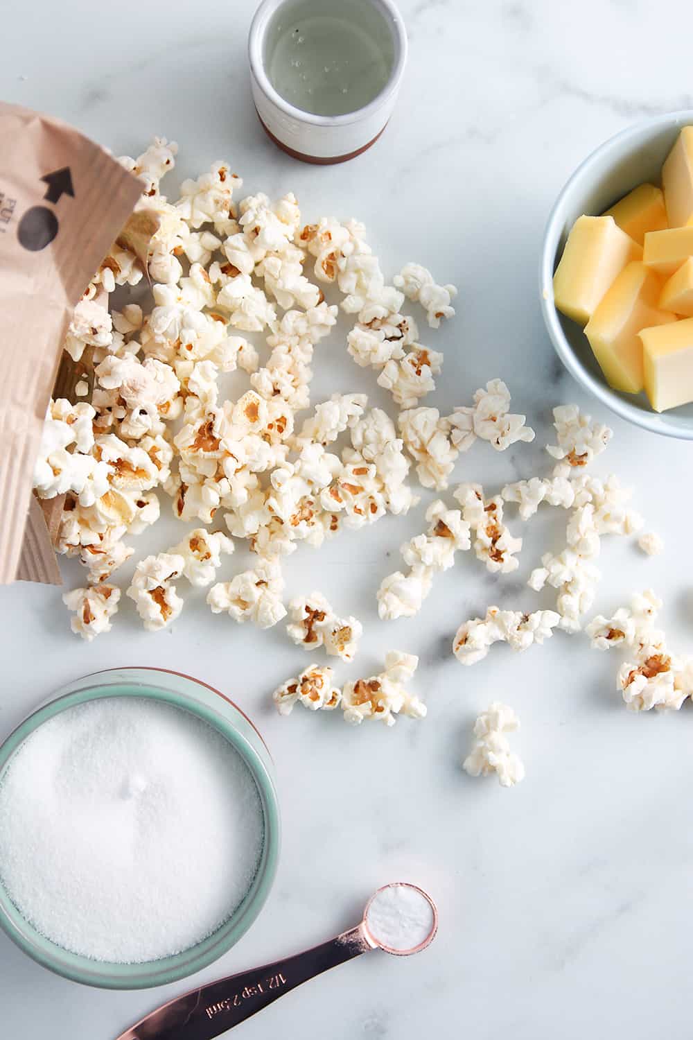 Ingredients for microwave caramel corn on a marble surface