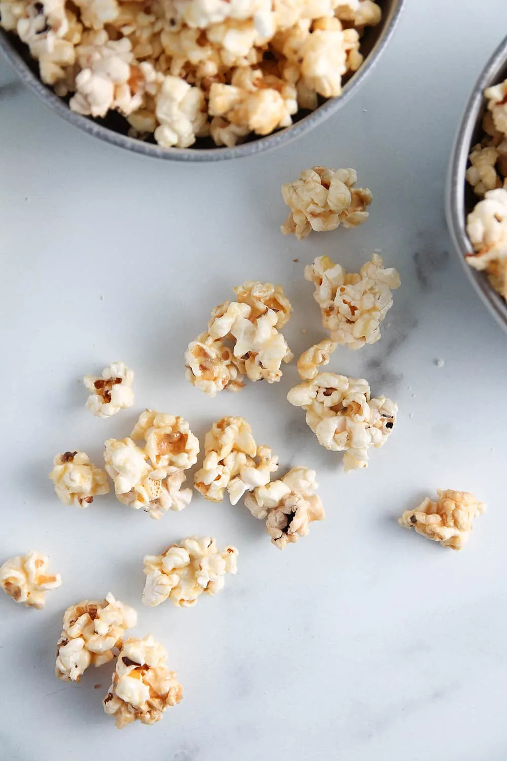 Pieces of microwave caramel corn scattered on a marble surface