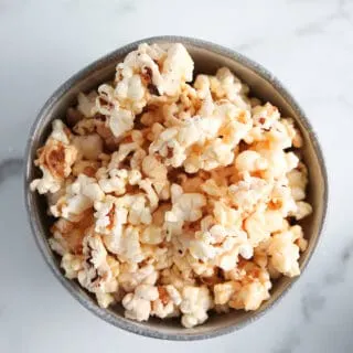 Bowl of microwave caramel popcorn on a marble surface
