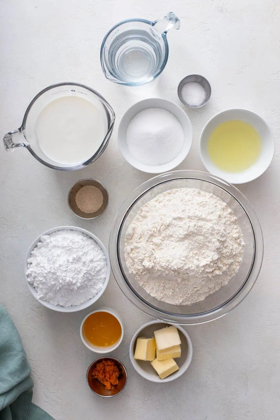 Ingredients for frosted orange rolls arranged on a countertop.