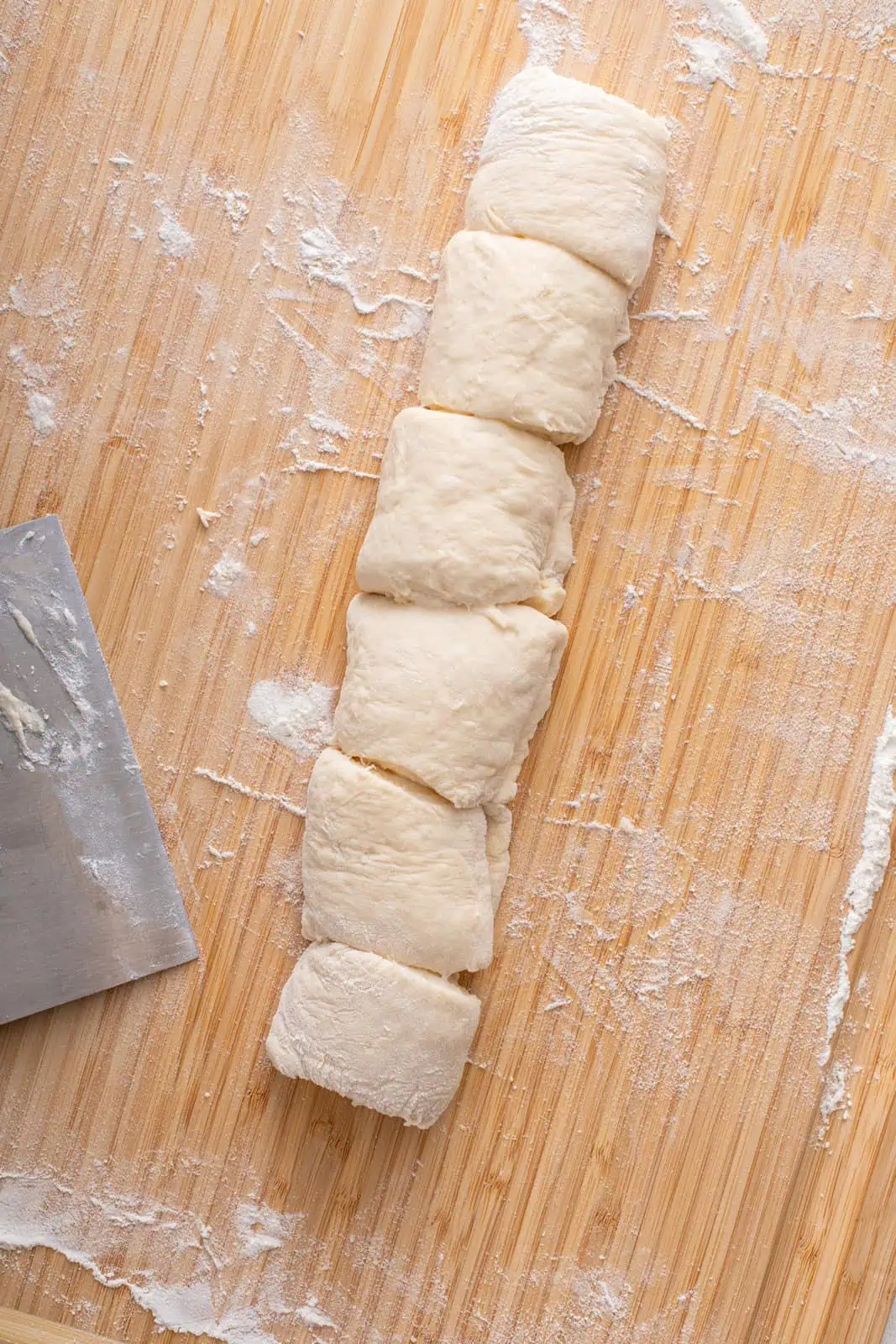 Roll of orange roll dough cut into 6 pieces.