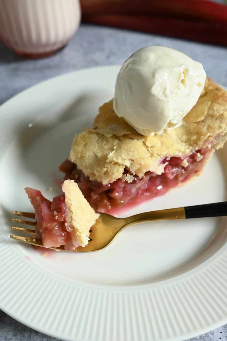 Gold fork with a bite of rhubarb pie.
