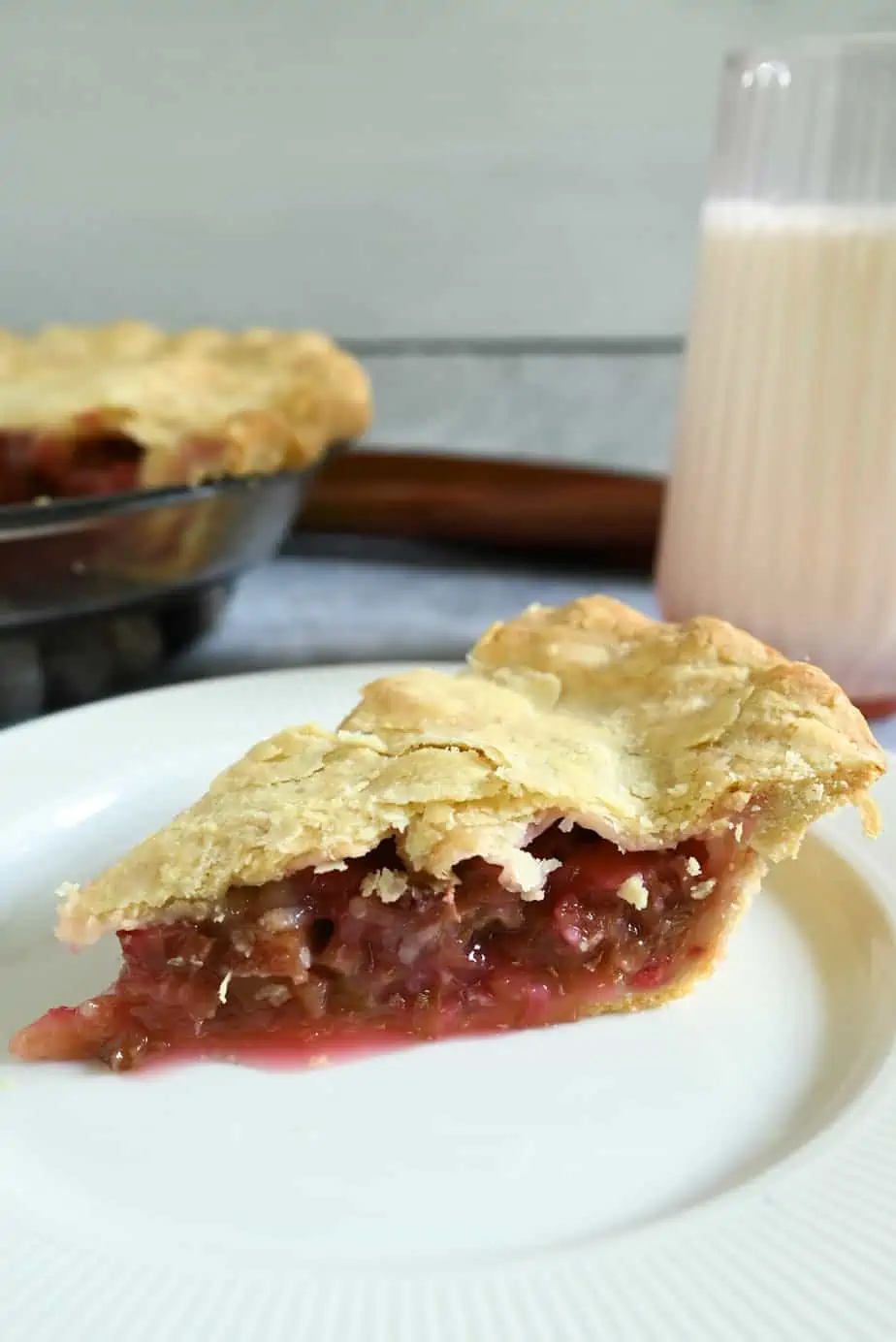 Slice of rhubarb pie on a white plate.