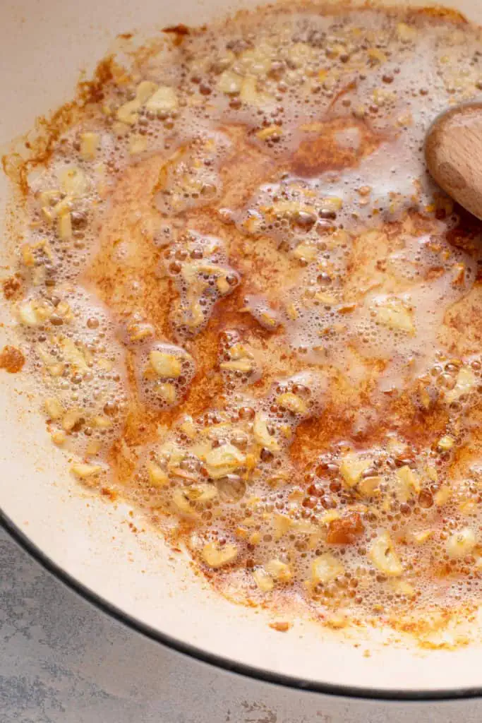 Garlic being sauteed in a skillet.