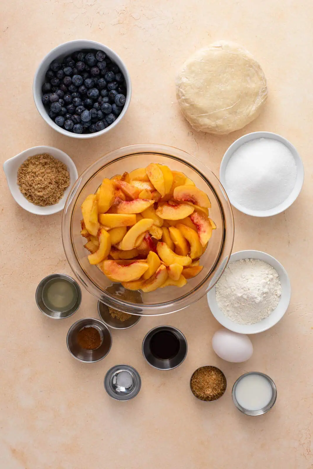 Ingredients for peach blueberry pie arranged on a countertop.