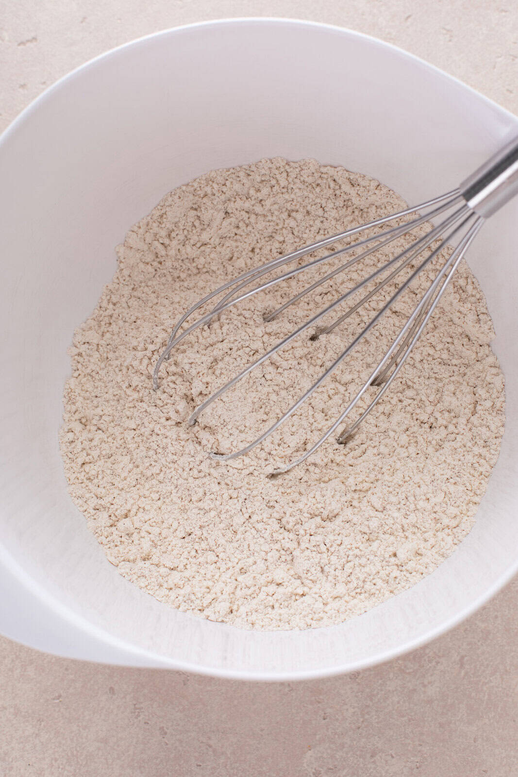 Dry ingredients for fruitcake cookies whisked in a bowl.