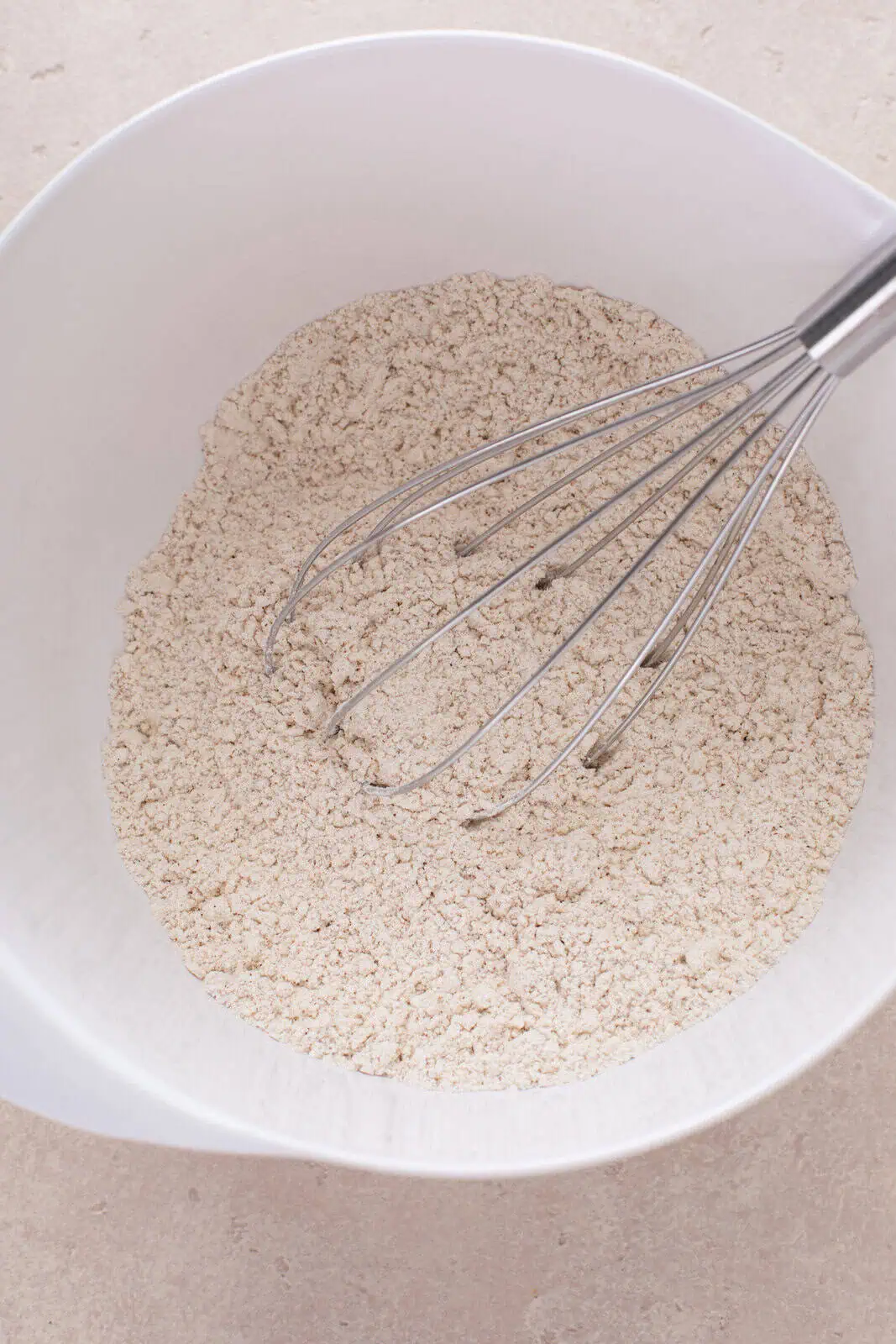 Dry ingredients for fruitcake cookies whisked in a bowl.