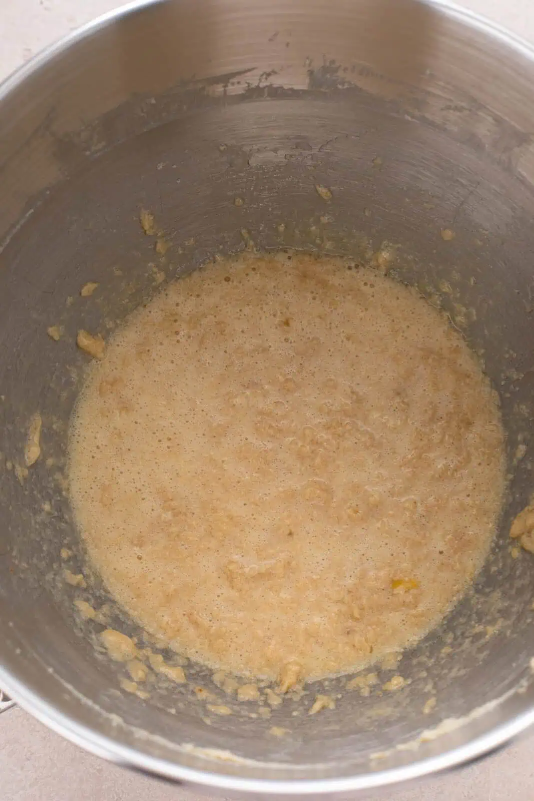 Wet ingredients for fruitcake cookies mixed in a metal bowl.