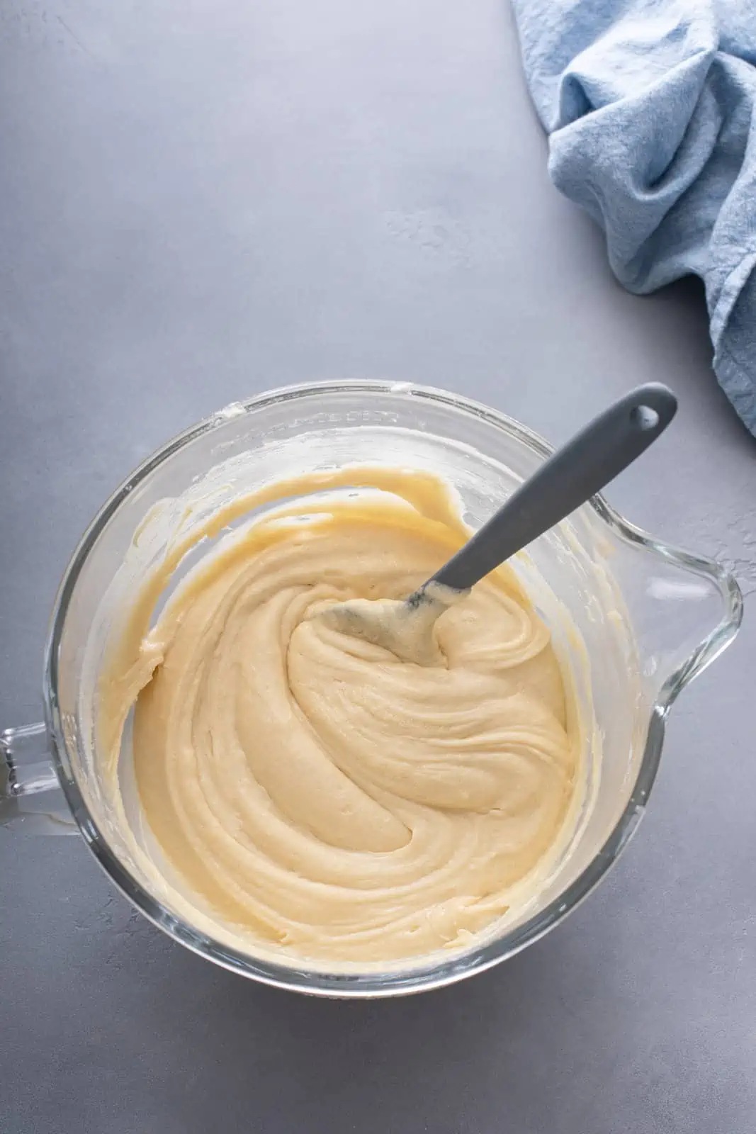 Batter for coconut cake in the bowl of a stand mixer.