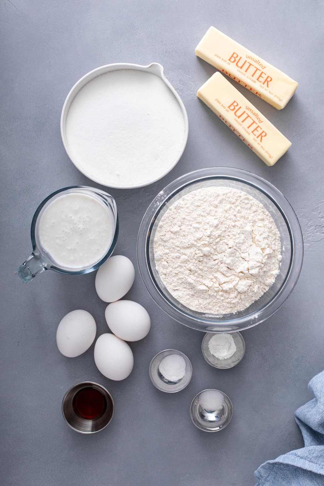 Ingredients for coconut cake layers arranged on a gray countertop.