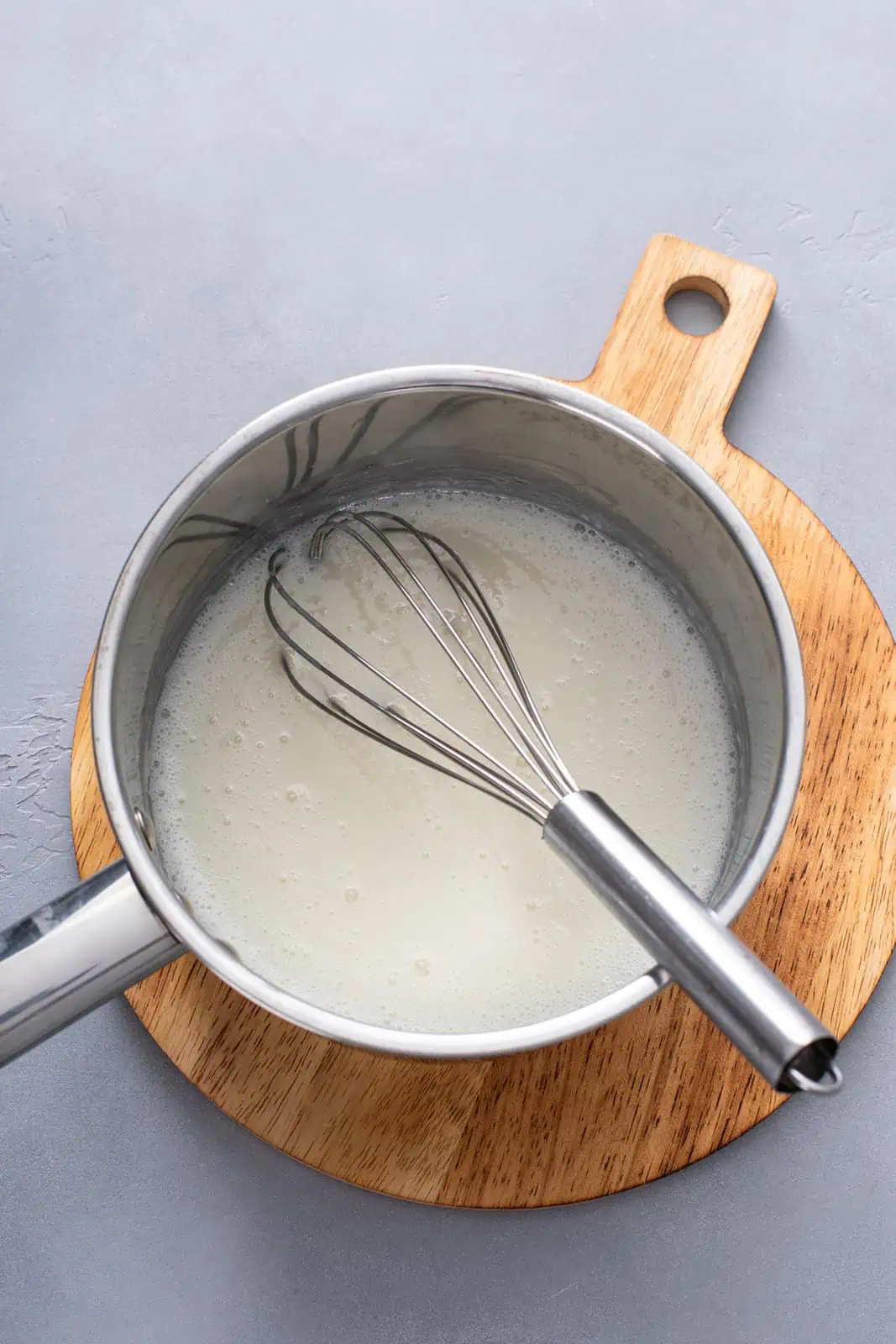 Thick milk mixture for coconut filling in a metal sauce pan.