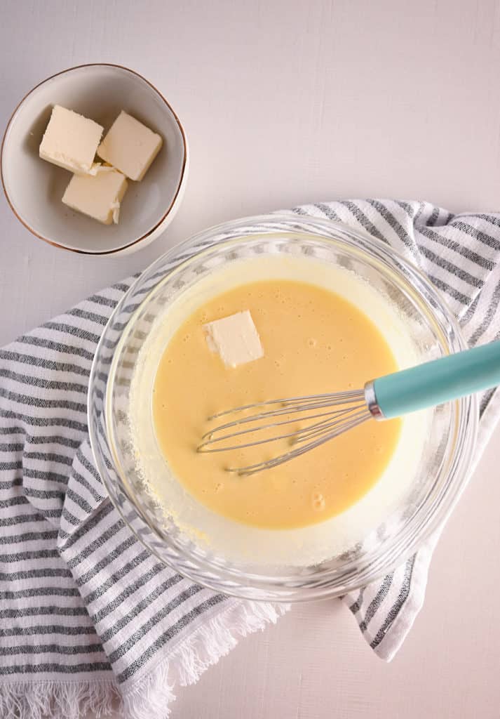 Jar of lemon curd set on a striped towel with a second jar in the background