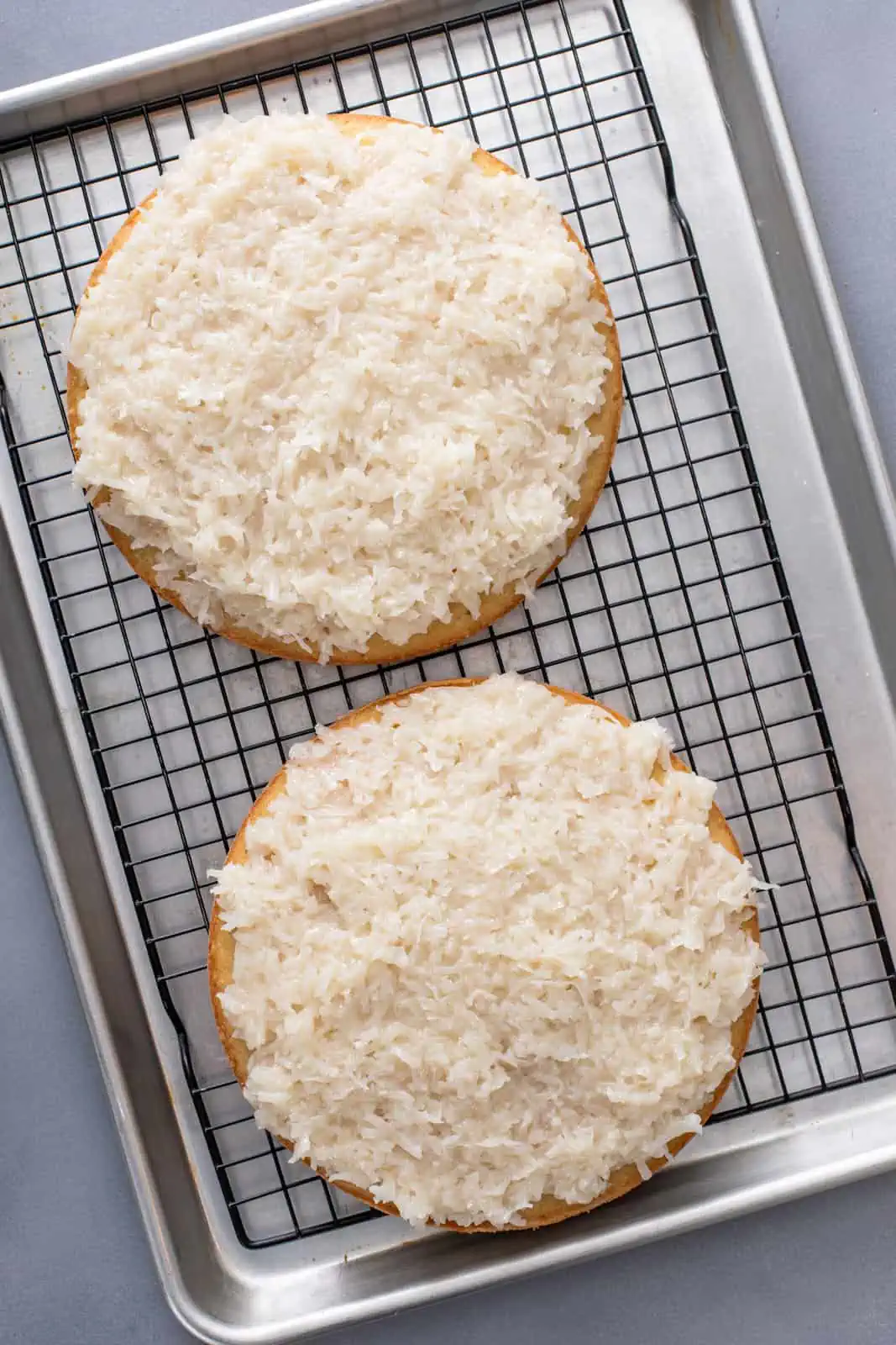 Two layers of coconut cake each topped with coconut filling.