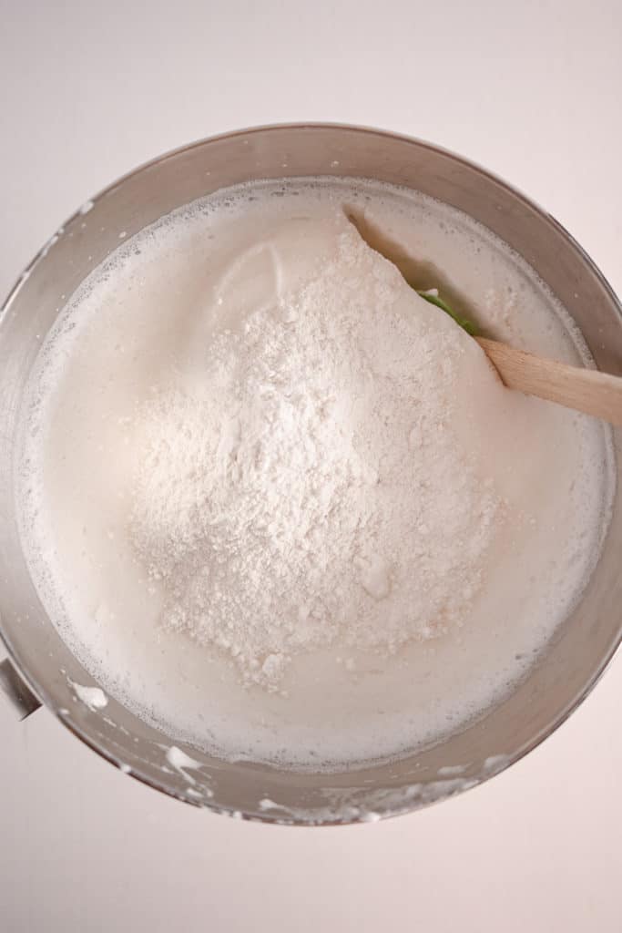 Spatula folding flour into whipped egg whites for angel food cake