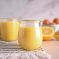 Close up of a glass jar filled with lemon curd