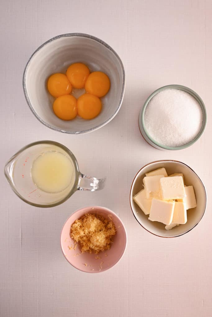 Jar of lemon curd set on a striped towel with a second jar in the background