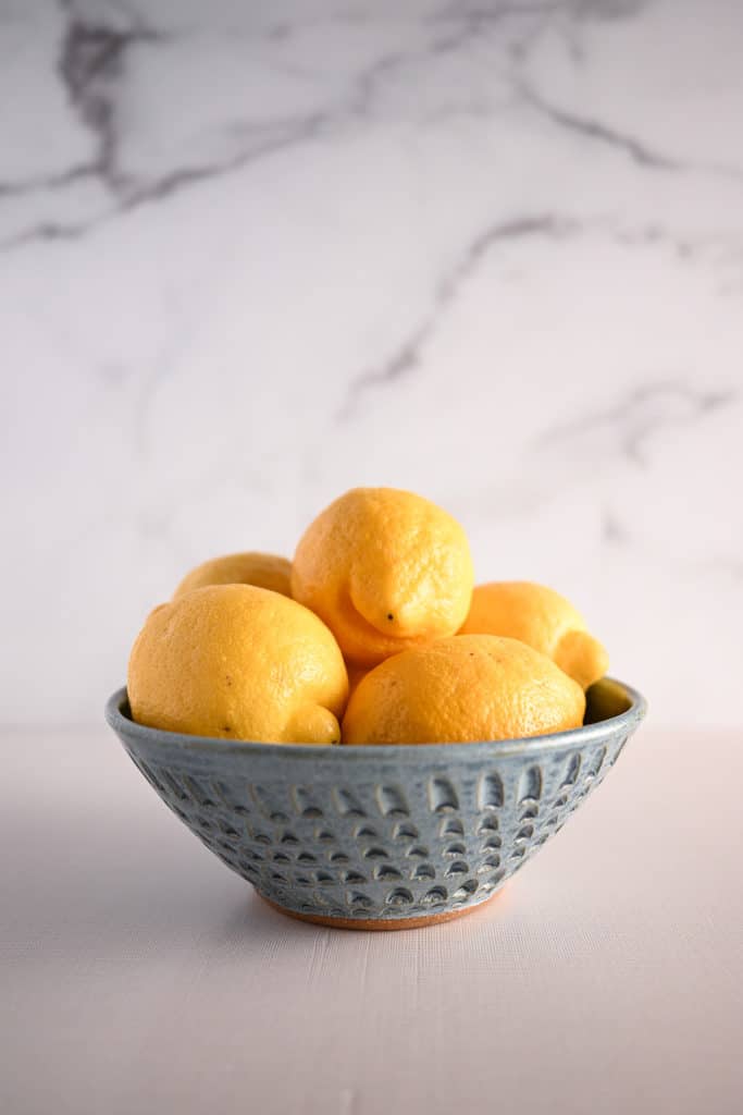 Blue pottery bowl filled with lemons