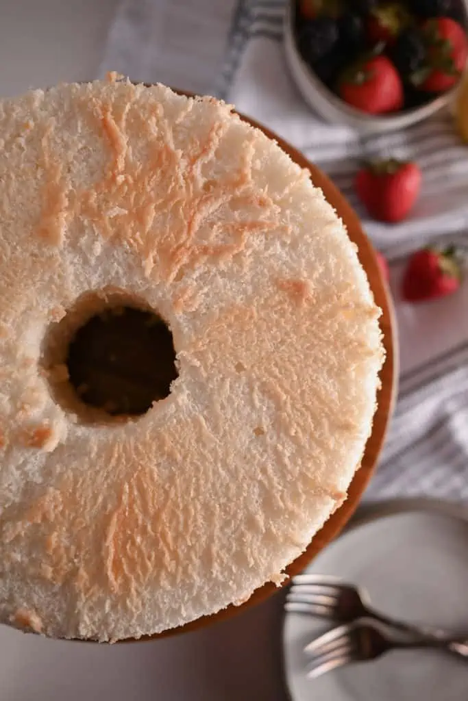 Overhead view of an angel food cake on a wooden cake plate