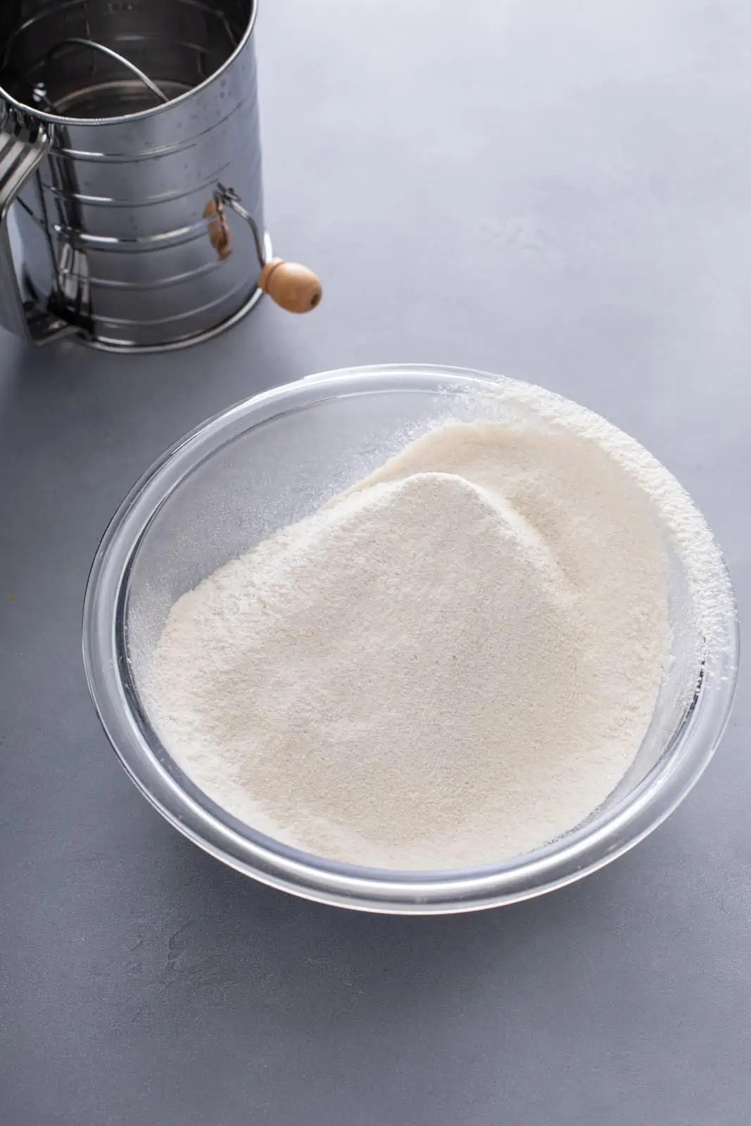 Dry ingredients for coconut cake sifted together in a glass bowl.