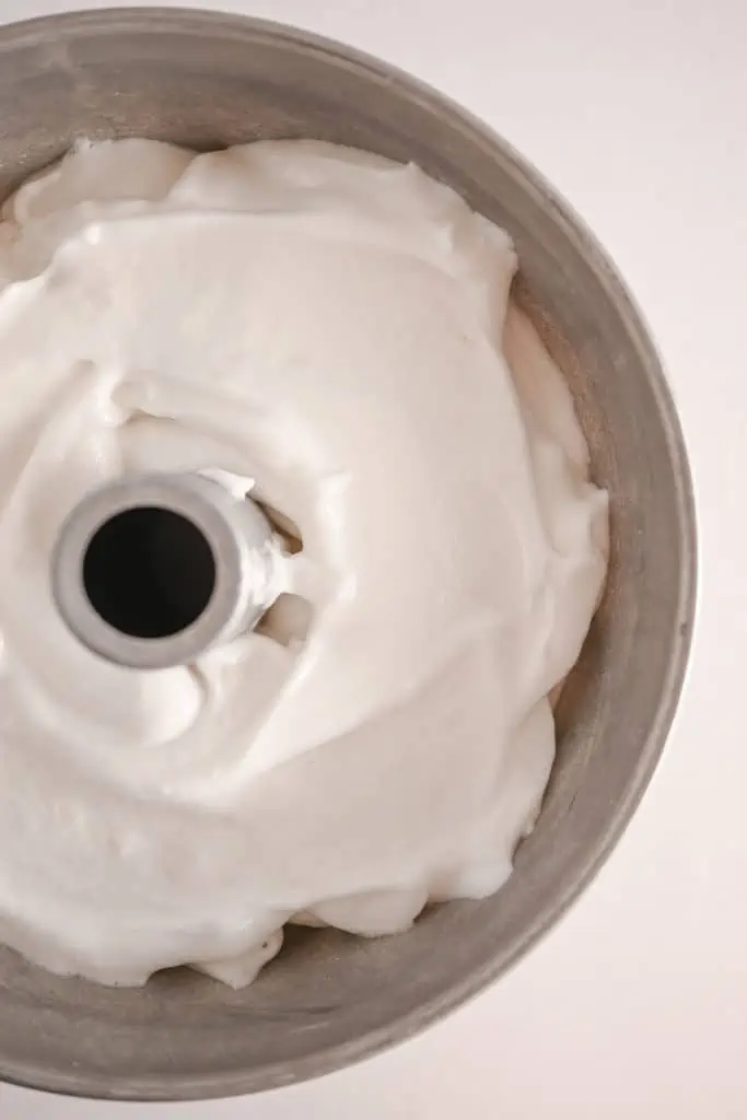 Angel food cake batter in an aluminum tube pan, ready to be baked