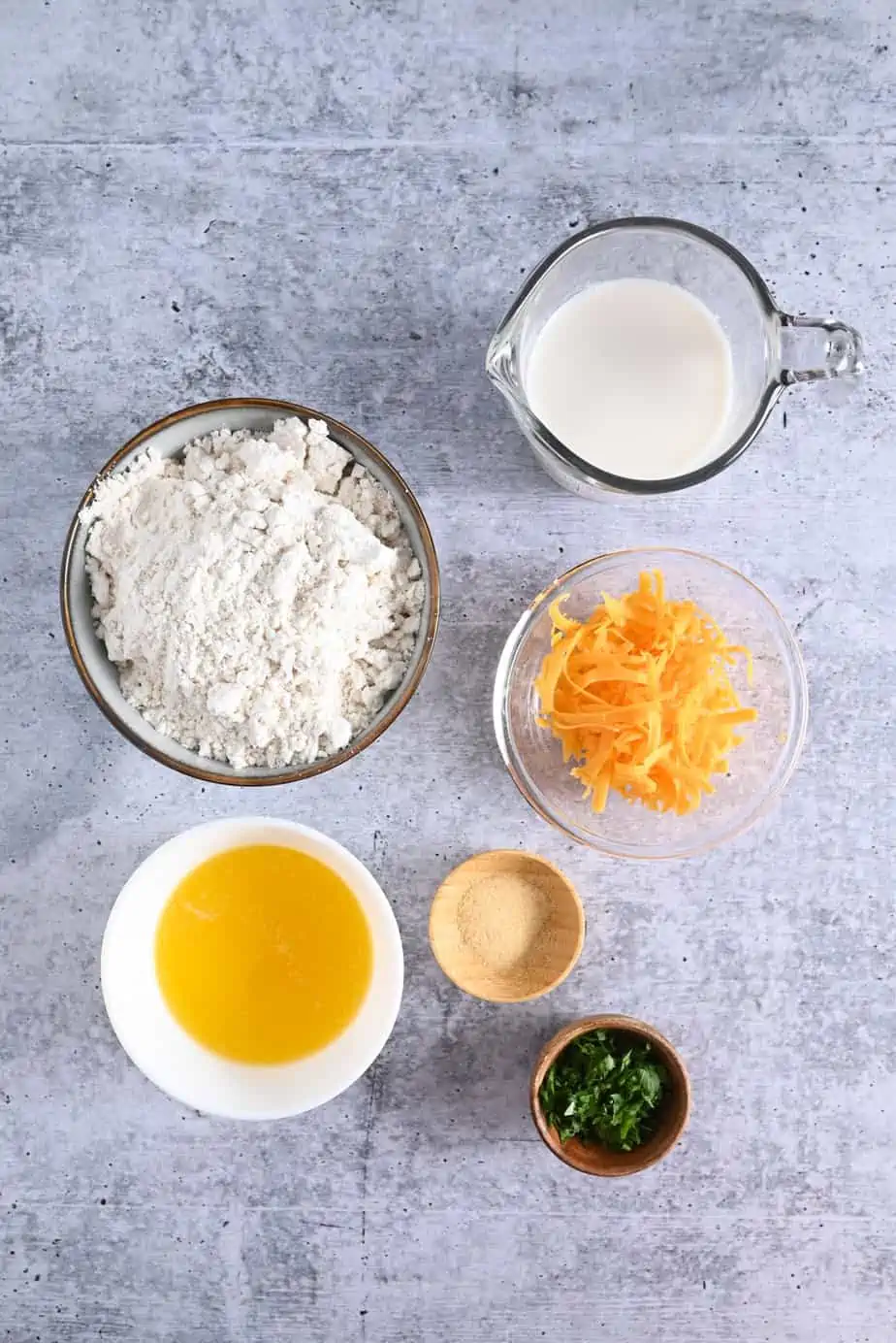 Ingredients for homemade red lobster biscuits arranged on a gray countertop.