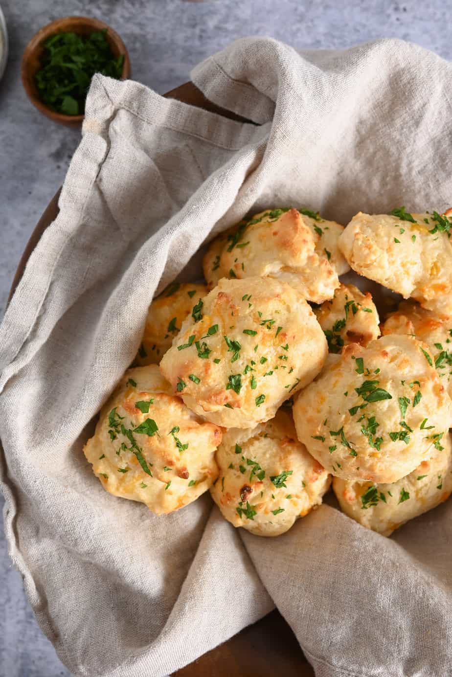 A batch of homemade red lobster biscuits in a towel-lined bread basket.