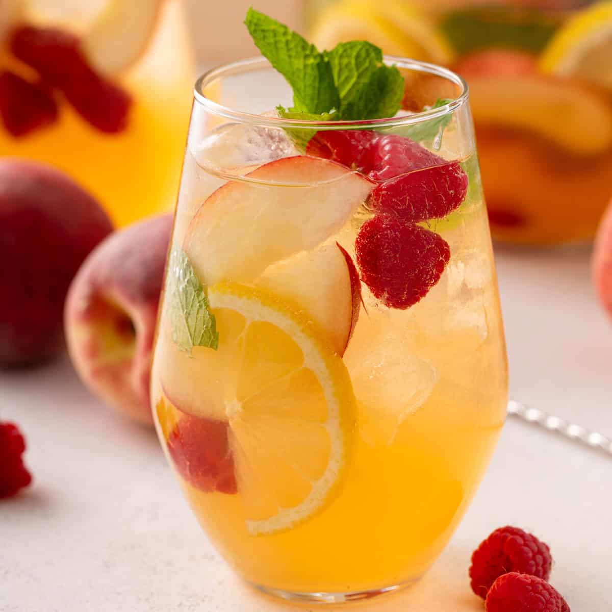 Glass filled with white peach sangria.