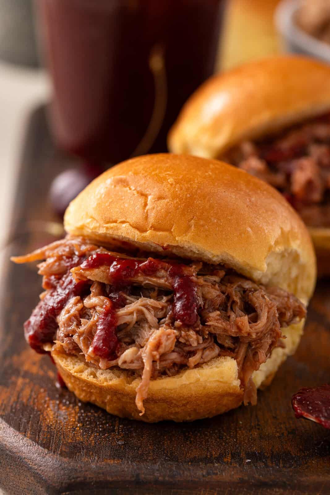 Pulled pork sandwich topped with cherry barbecue sauce.