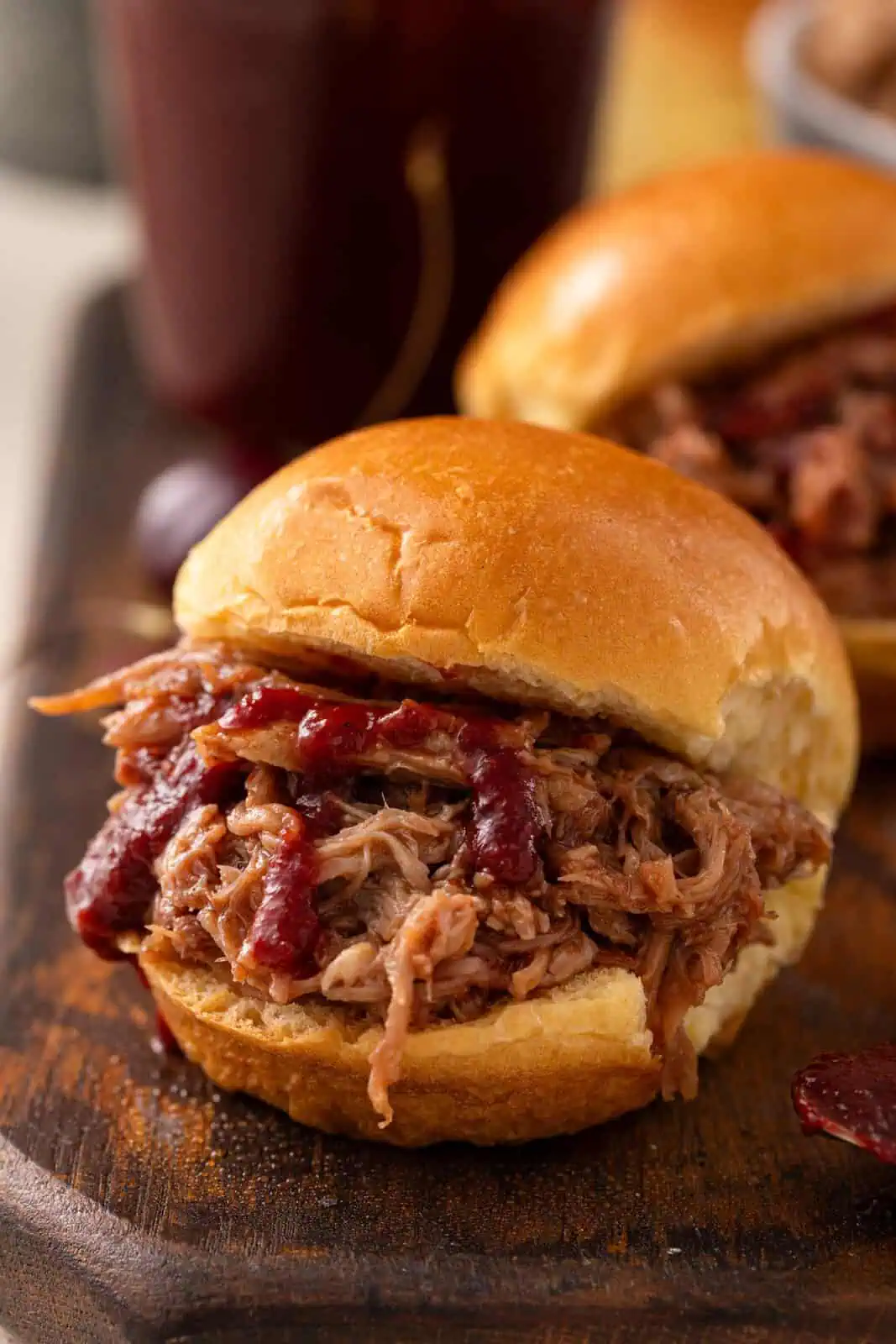 Pulled pork sandwich topped with cherry barbecue sauce.
