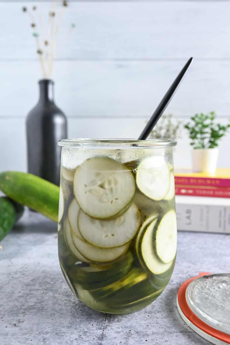 Open jar filled with pickled cucumbers, with the handle of a fork sticking out of the top.