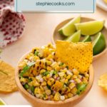 Tortilla chip in a bowl of roasted corn salsa. Text overlay includes recipe name.