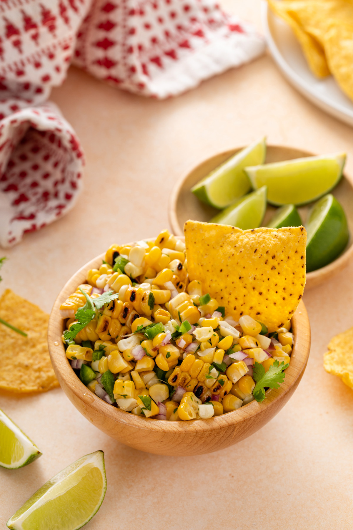 Tortilla chip in a bowl of roasted corn salsa.