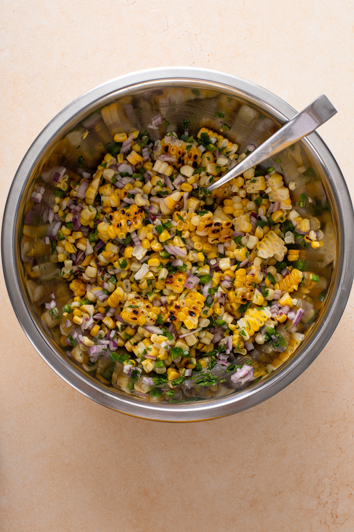 Mixed roasted corn salsa in a metal bowl.