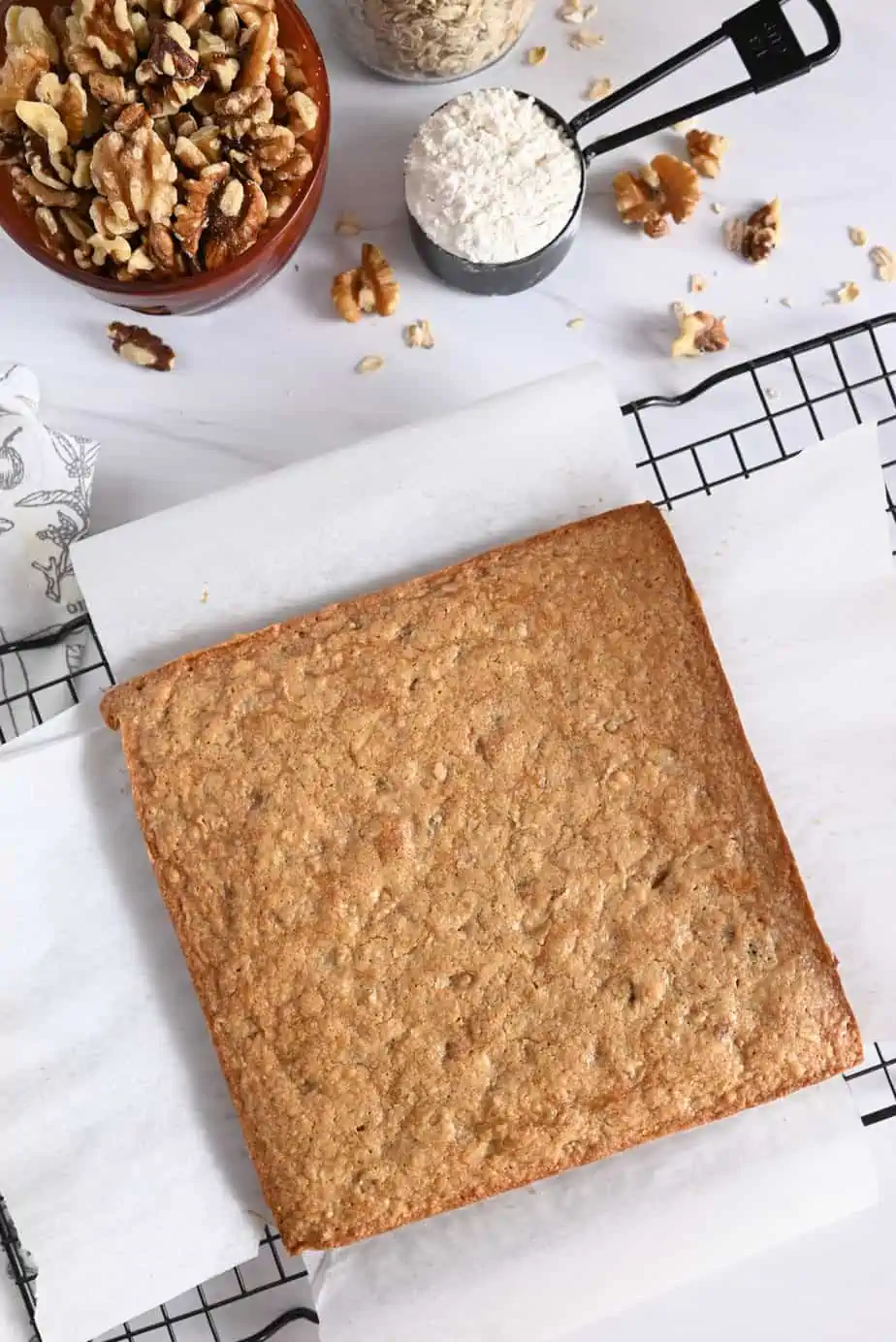 Baked maple walnut blondies cooling on a wire cooling rack.