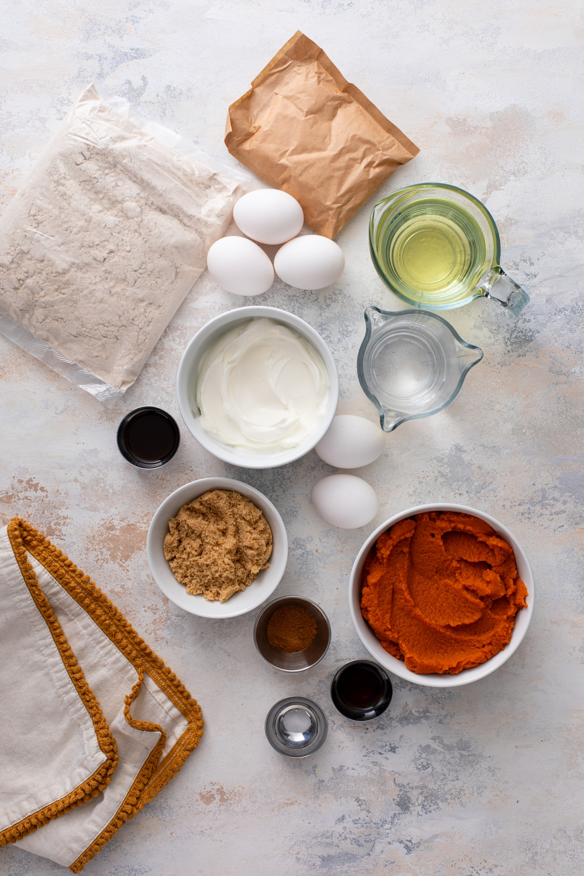 Ingredients for easy pumpkin spice cake arranged on a countertop.