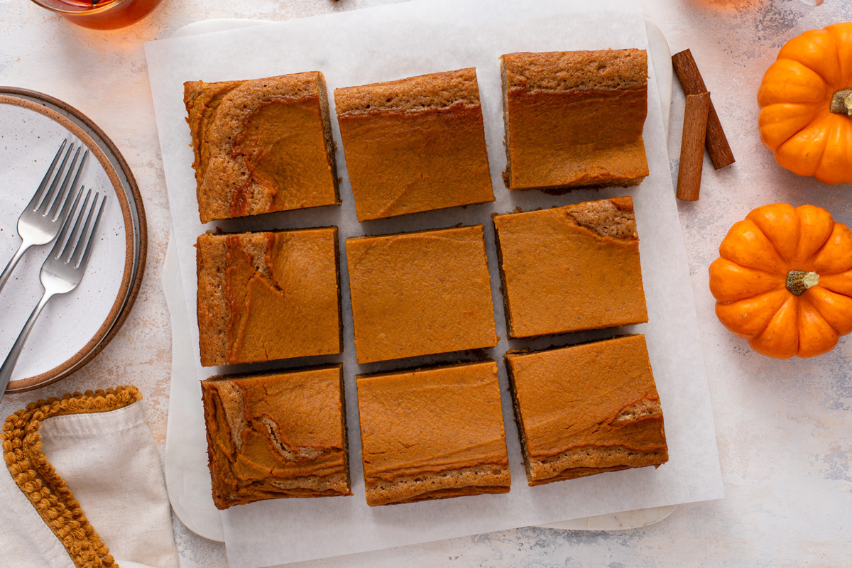 Overhead view of cooled pumpkin spice cake cut into squares.
