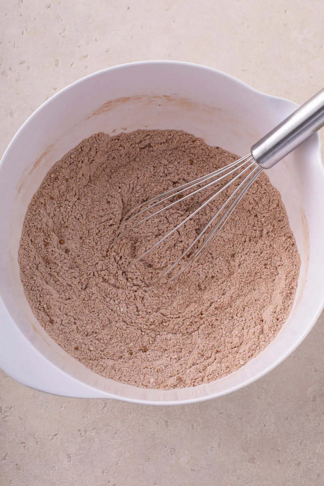 Dry ingredients for easy chocolate cupcakes whisked in a white mixing bowl.