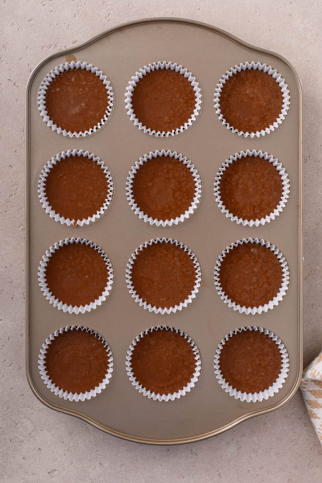 easy chocolate cupcake batter divided into lined muffin wells, ready to go in the oven.